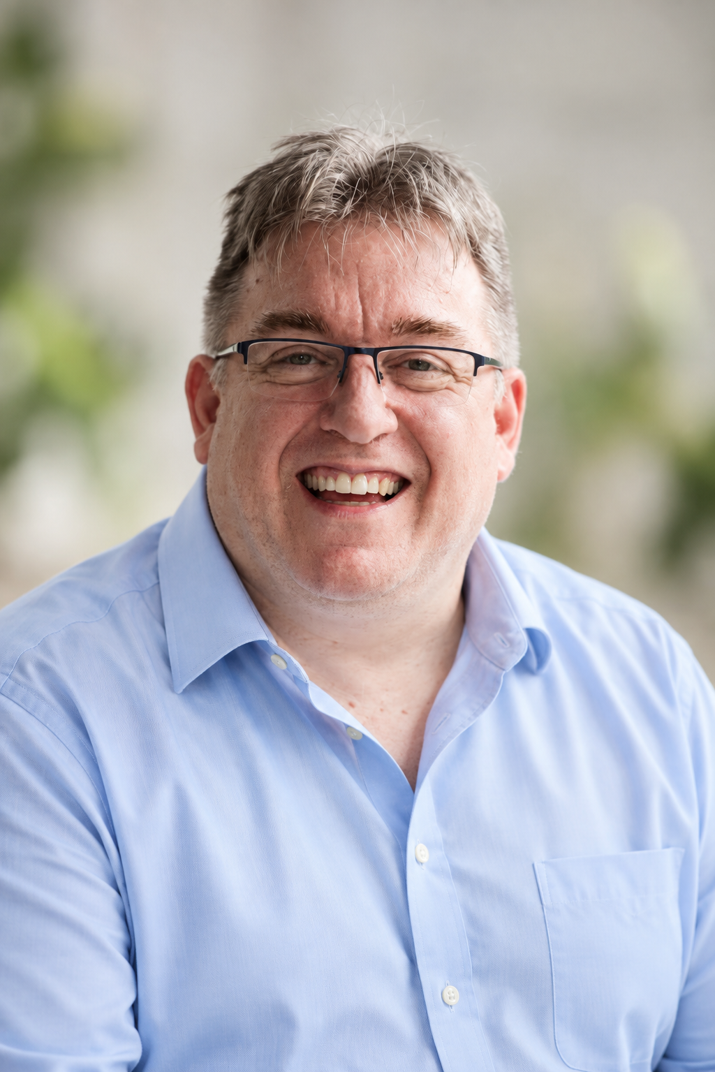 Michel Bergeron smiling, wearing a light blue shirt.